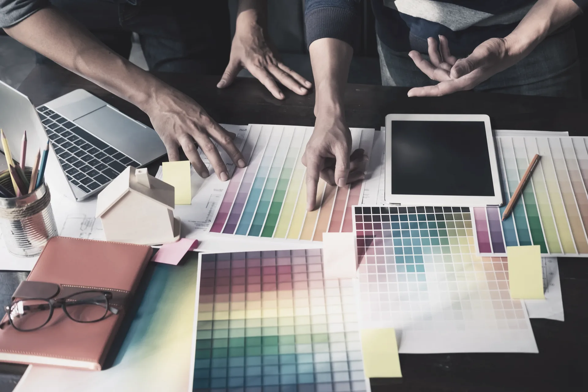 A team working over colour swatch fans and a tablet